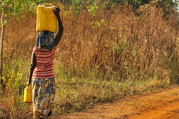 woman carrying water can