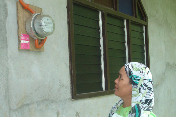 Bai Aniza checks an electric meter.