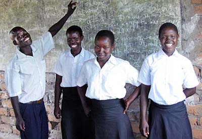 Children in South Sudan in a classroom, standing by the chalkboard.