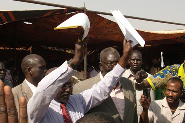 Governor Paul Malong displays a joint communiqué between the Dinka Malual and Rezeigat to a crowd gathered in Aweil.